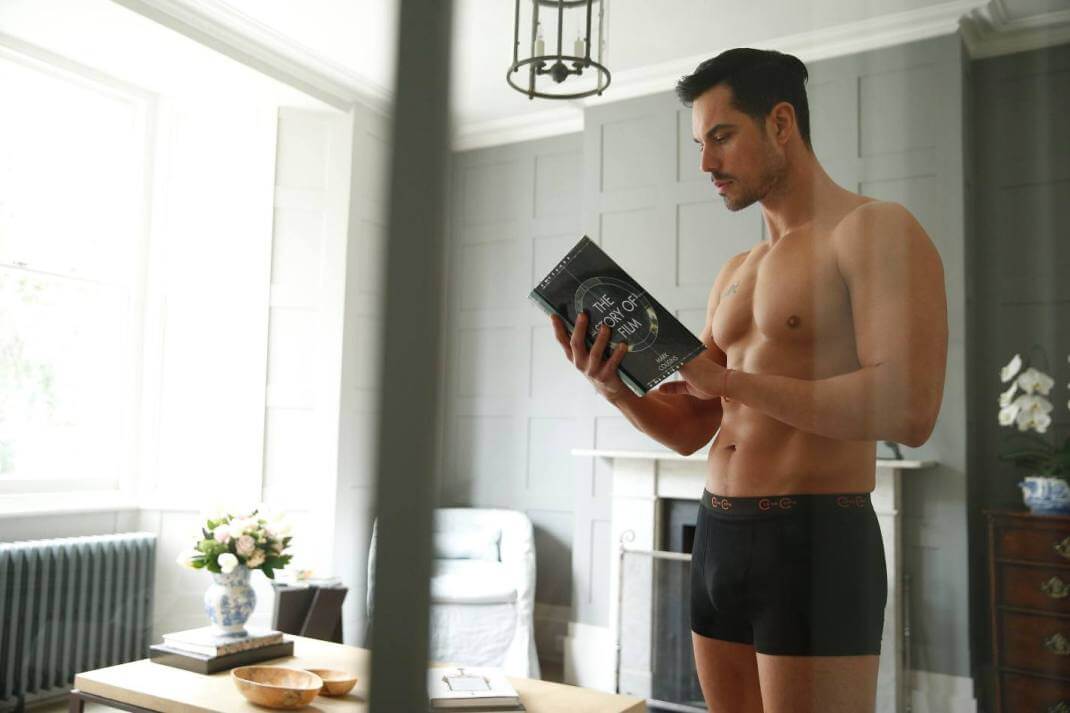 Men in boxer short reading a book