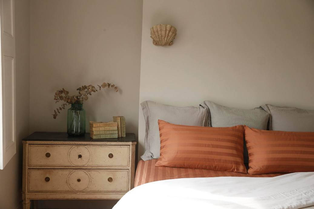 bed with copper linen and desk near the head support